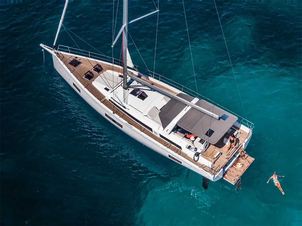Auf der Beneteau Oceanis 54 schwimmt eine Person im Wasser.
