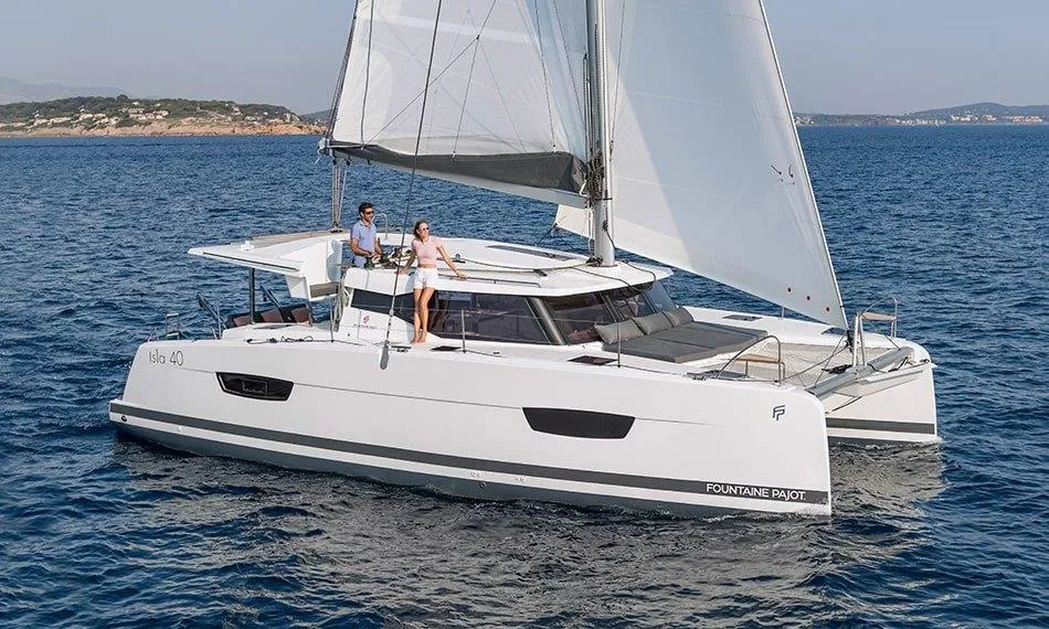 Ein weißer Katamaran Fountaine Pajot Isla 40 mit zwei Personen darauf.